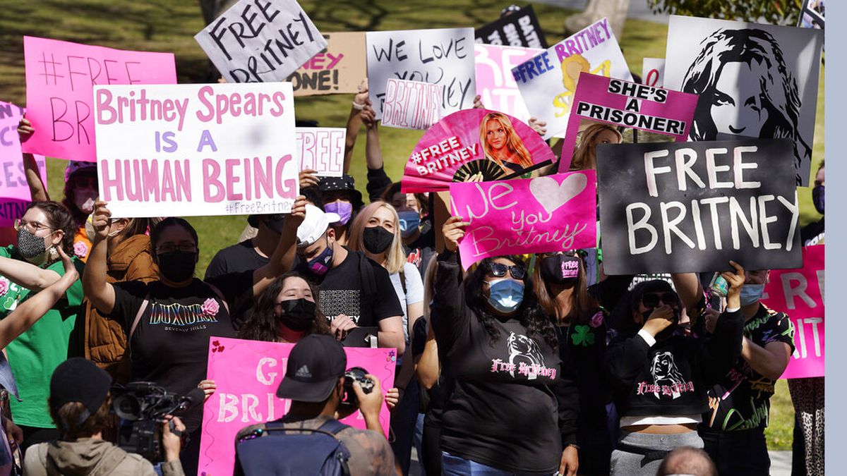 Britney Spears fans hold signs outside a court hearing concerning the pop singer's...