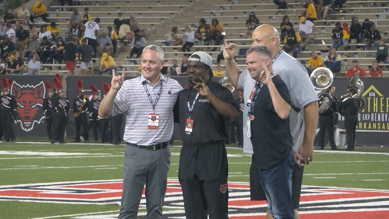Vice Chancellor of Intercollegiate Athletics Jeff Purinton poses with Reggie Arnold...
